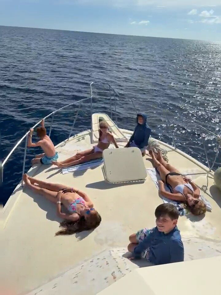Family relaxing together on the bow during a Nassau fishing excursion